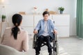 Psychological help service. Disabled teen boy in wheelchair having psychotherapy session with counselor at clinic Royalty Free Stock Photo