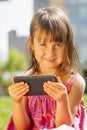 Psychological image of cute little girl addicted to likes: Social networks feeds her neediness. Close up sad child with mobile Royalty Free Stock Photo