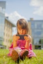 Psychological image of cute little girl addicted to likes: Social networks feeds her neediness. Portrait of child with mobile Royalty Free Stock Photo