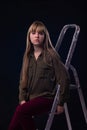 Psychological portrait of a girl sitting on a ladder