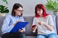 Psychologist counseling teenage female, individual therapy in doctors office.