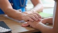 Psychologist or gynecologist holds hands of a female patient and provides professional psychological assistance closeup