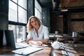 Psychologist listens to the patient. Businesswoman with curly blonde hair indoors in a cafe at daytime