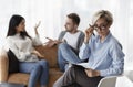 Psychologist Looking At Camera While Clients Having Quarrel In Office Royalty Free Stock Photo