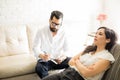 Psychologist making notes during therapy session with patient