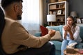 Psychologist man doctor making notes consulting female patient in bright office mental health care concept. Psychotherapist Royalty Free Stock Photo