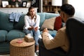 Psychologist man doctor making notes consulting female patient in bright office mental health care concept. Psychotherapist Royalty Free Stock Photo