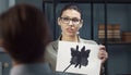 Psychologist showing Rorschach Inkblot card