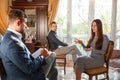 The psychologist speaks to the girl and makes notes in a notebook sitting on chairs Royalty Free Stock Photo