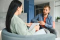 Psychologist talking with patient on therapy session. Depressed man speaking to a therapist while she is taking notes. Royalty Free Stock Photo