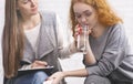 Psychotherapist comforting female patient, giving her glass of water to calm