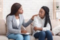 Psychotherapist comforting sad female patient during therapy session in office