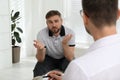 Psychotherapist working with drug addicted young man indoors