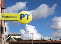 PT Poste Italiane sign outside a local city branch against blue cloudy sky .