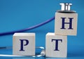 PTH - acronym on wooden large cubes on blue background with stethoscope