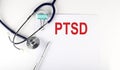 PTSD text written on the paper with a stethoscope. Medical concept