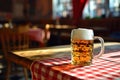 Pub interior, a mug of beer on top of a wooden table covered with red and white checkered tablecloth Royalty Free Stock Photo