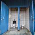 Public bathroom with blue open doors Royalty Free Stock Photo