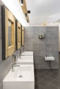 Public bathroom with five sinks, mirrors and soap dispensers. Modern and simple Royalty Free Stock Photo