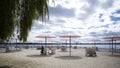 A public beach park with pink umbrellas and Muskoka chairs Royalty Free Stock Photo