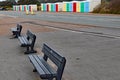 Public benches by the roadside in Exmouth, Devon, in front of a row of multi coloured beach huts Royalty Free Stock Photo