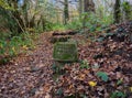 Public Bridleway. Stone marker in woodland.