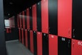 Public changing room in the gym. Closed shelves for storage. Cabinets with locks in red and black.