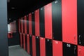 Public changing room in the gym. Closed shelves for storage. Cabinets with locks in red and black.