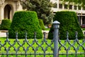 public city park in Budapest with decorative old gray cast iron railing. low picket fence. lush green lawn Royalty Free Stock Photo