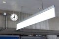 Public clock and blank sign board for information in railway station at the hanging with roof of subway central train station. It Royalty Free Stock Photo