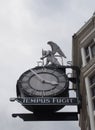 Public clock and figure on the historic 19th century time ball building in briggate leeds city centre, translation under the clock