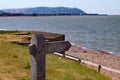 A public footpath sign stands in front of a sunny bay at Blue Anchor in Somerset. Looking west towards Minehead and Porlock Royalty Free Stock Photo