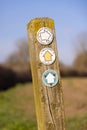 Public footpath signs and labels on a wooden post in the countryside. UK