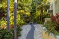 Public Garden with diverse flora a stone path, floor, chairs and table. Royalty Free Stock Photo