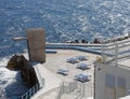 Public lido in funchal madeira with concrete diving platform sun loungers and steps to a sunlit blue sea