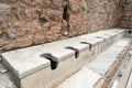 Public multi seat toilet marble stone and rock at spectacular antique ruins in Ephesus at Selcuk Izmir, Turkey. Historical Ancient