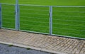 Public multifunctional city playground with green artificial turf. soccer goals. protective white nets and game lines. around are