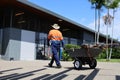 Public municipal worker pulling a wheelbarrow