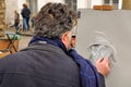 Public painter with his paintings in Place du Tertre square in Paris' XVIIIe arrondissement (Montmartre) Royalty Free Stock Photo