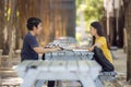 At the public park, a happy young couple using a laptop sits at a table