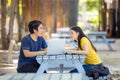 At the public park, a happy young couple using a laptop sits at a table Royalty Free Stock Photo