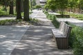 Public park in summer time, greenery, path throw and bench, sunny, blue sky Royalty Free Stock Photo