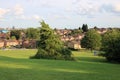Public park with trees houses and city skyline in background UK
