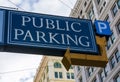 Public parking sign with neon arrow advertises parking garage location for residents and visitors of historic city center Royalty Free Stock Photo