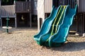 Public playground with merry go round spin, plastic triple slide under construction yellow caution tape woodchips mulch area in Royalty Free Stock Photo