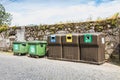 Public recycling bins in front of a stone wall in vila cha, portugal