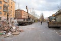 Public service workers put demolition waste of old pavilions in a truck with a crane in an alley near a residential building