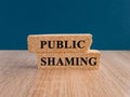 Public shaming symbol. Concept words Public shaming on brick blocks on a beautiful wooden table, dark blue background Royalty Free Stock Photo