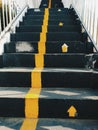 Public staircase with yellow lines to divide the way up and the way down / Signs of the way to up stairs but have no signs to way