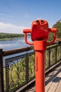 Public stationary binoculars on the banks of the river in summer